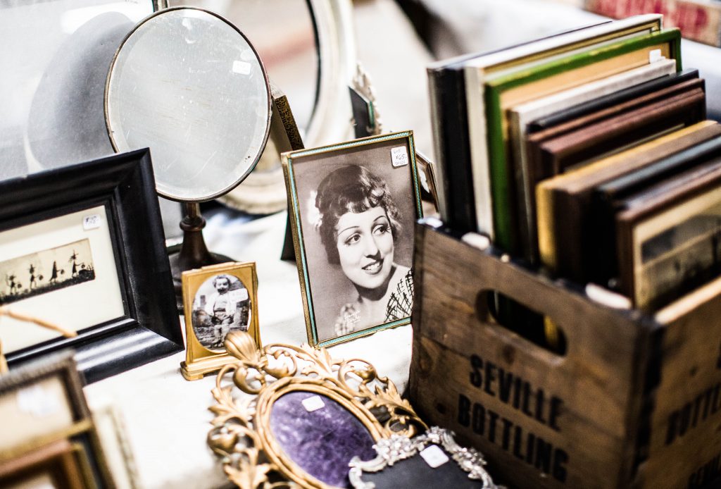 vintage family photos in frames on desk next to crate full of picture frames