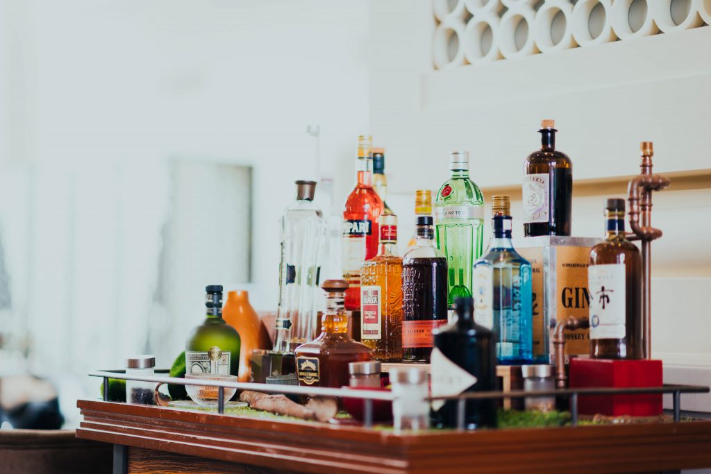 home bar cart with various liquor bottles