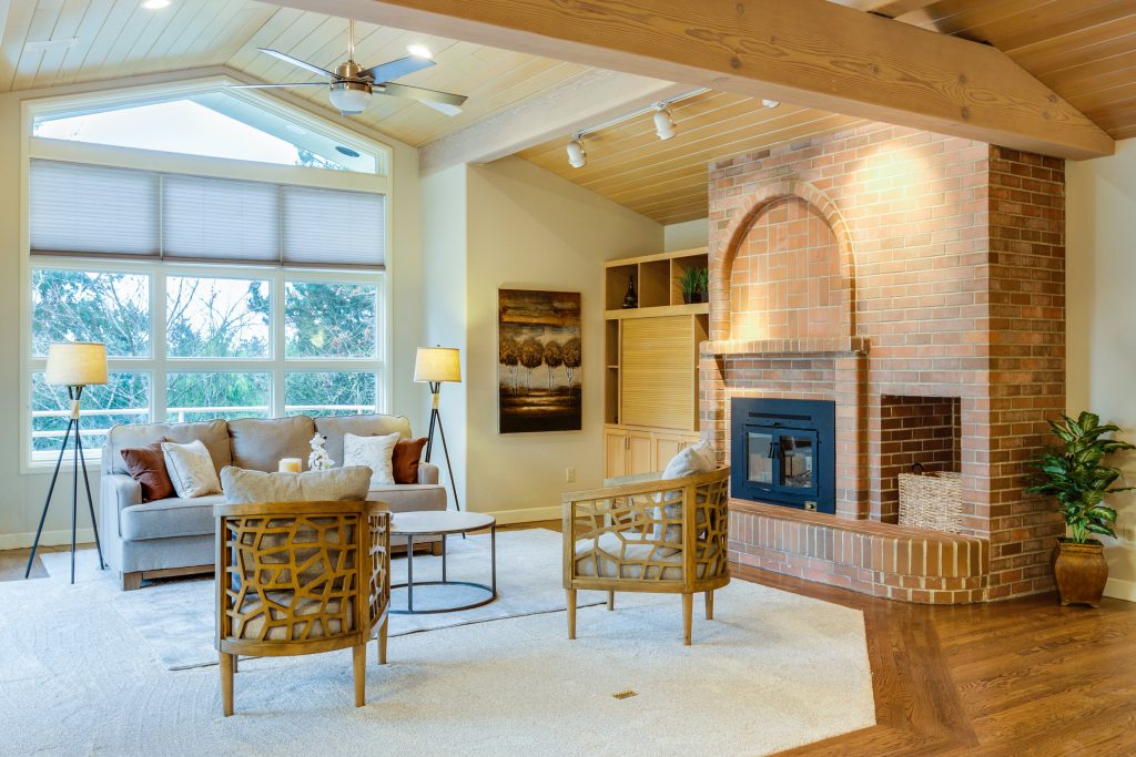 brick fireplace in living room with vaulted ceilings