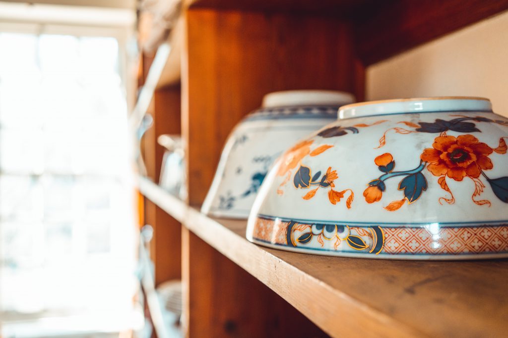 porcelain bowls with floral print turned upside down on shelf