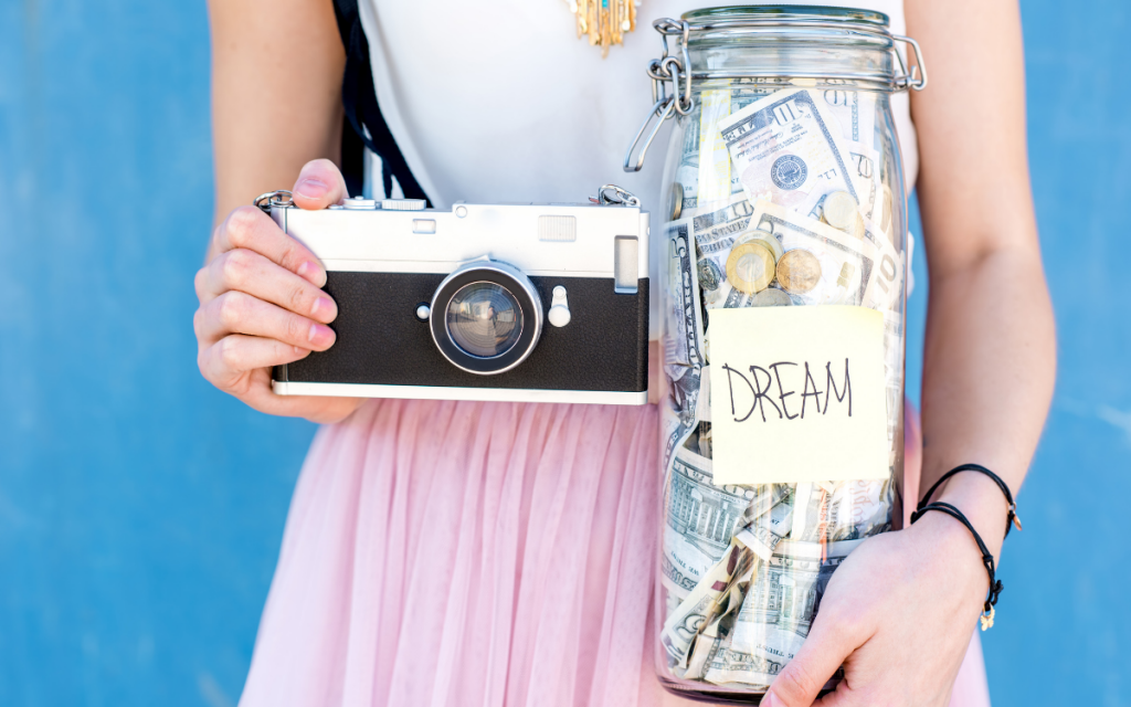 girl holding camera and jar of money savings