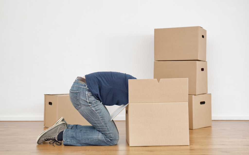 man looking for stuff in cardboard box moving