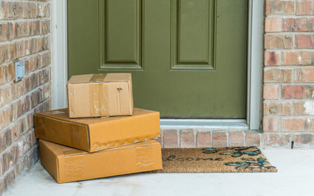 packages stacked on welcome mat at front door