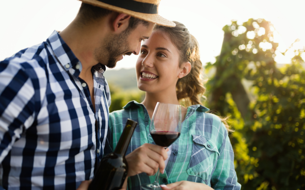 couple tasting wine in a vineyard