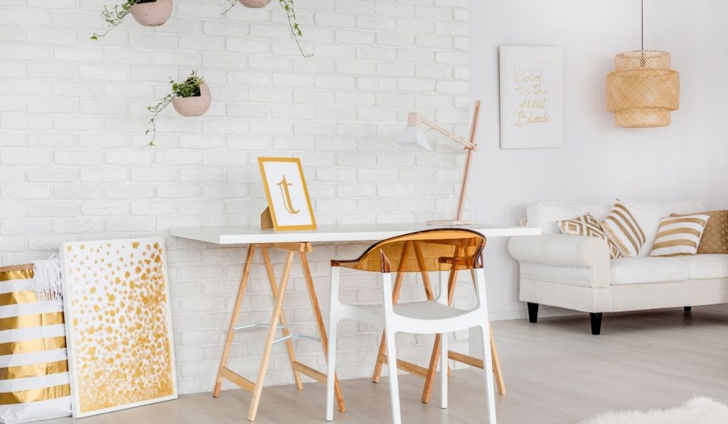 micro apartment with a work space and sofa; white and gold colors