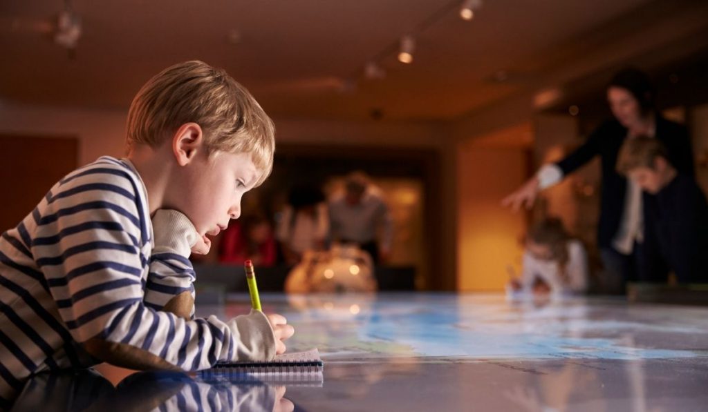 child taking notes in the museum