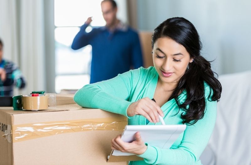 woman checking inventory list for packing
