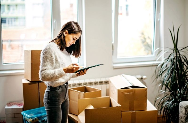 woman checking her list and categorizing things for moving