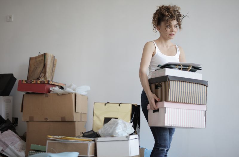 woman holding couple of boxes decluttering her stuff