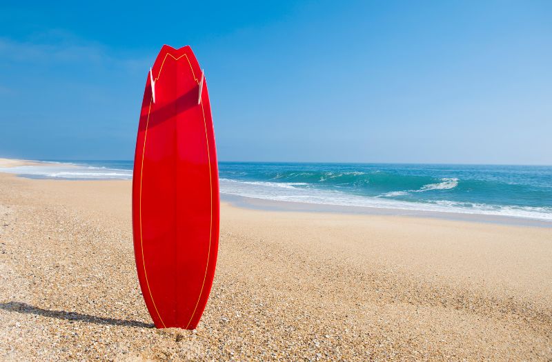 red surfboard on the beach