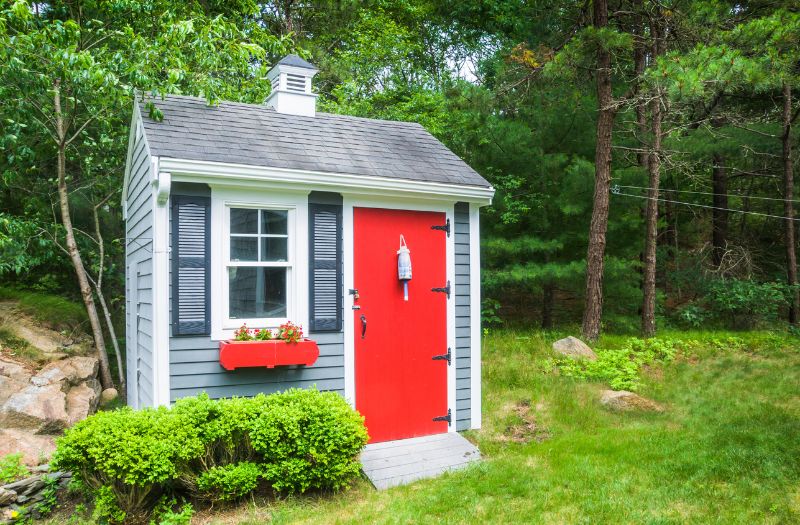 cute design of a shed with a red door