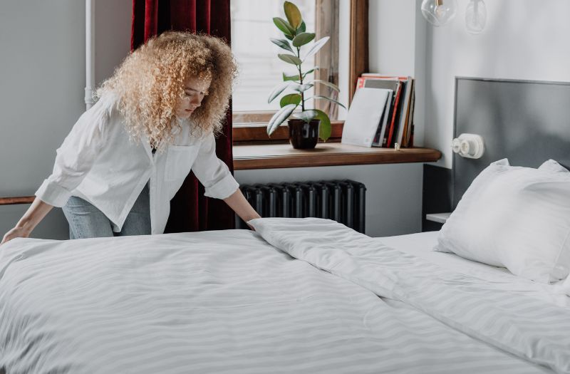 woman changing the linens in the guest bedroom