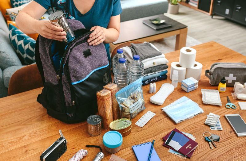 woman packing food, medicines, clothes for a go-bag