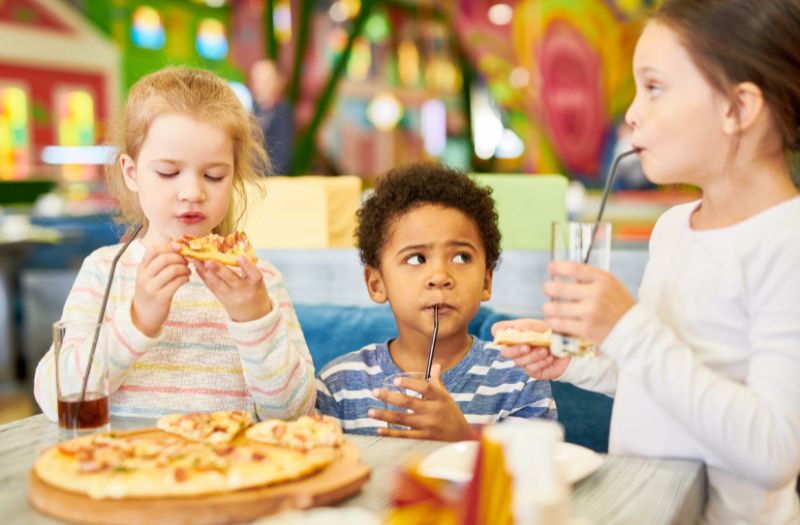 kids eating pizza in a restaurant