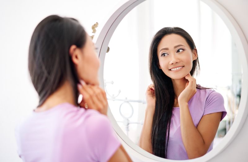 woman smiling looking at the mirror
