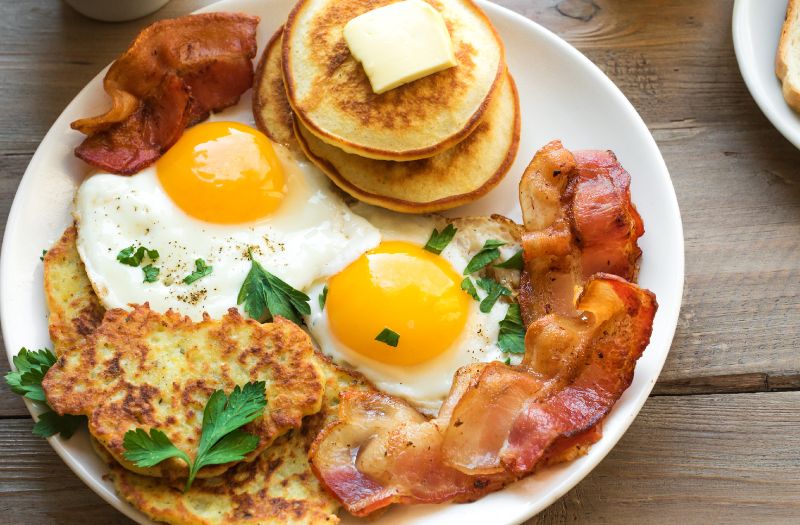 hearty breakfast plate, with pancakes, eggs and bacon