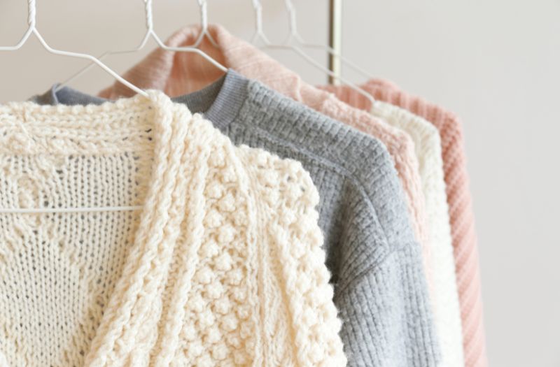 cute winter sweaters on white hangers