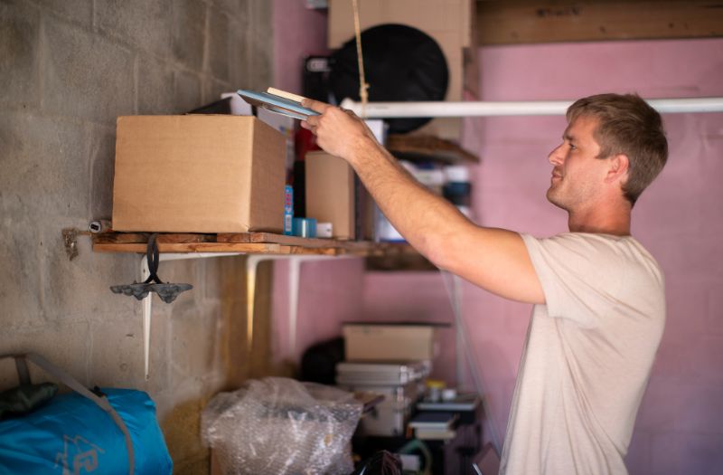 man trying to organize his garage storage