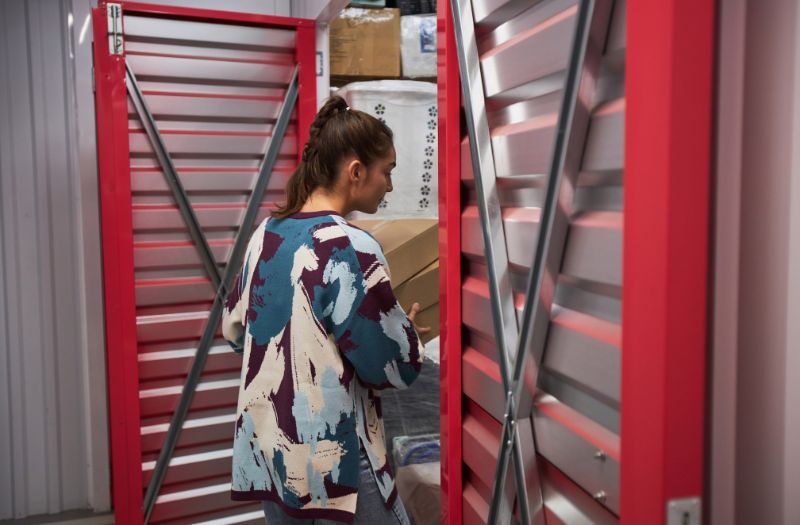 woman checking her storage unit, bringing some boxes to store